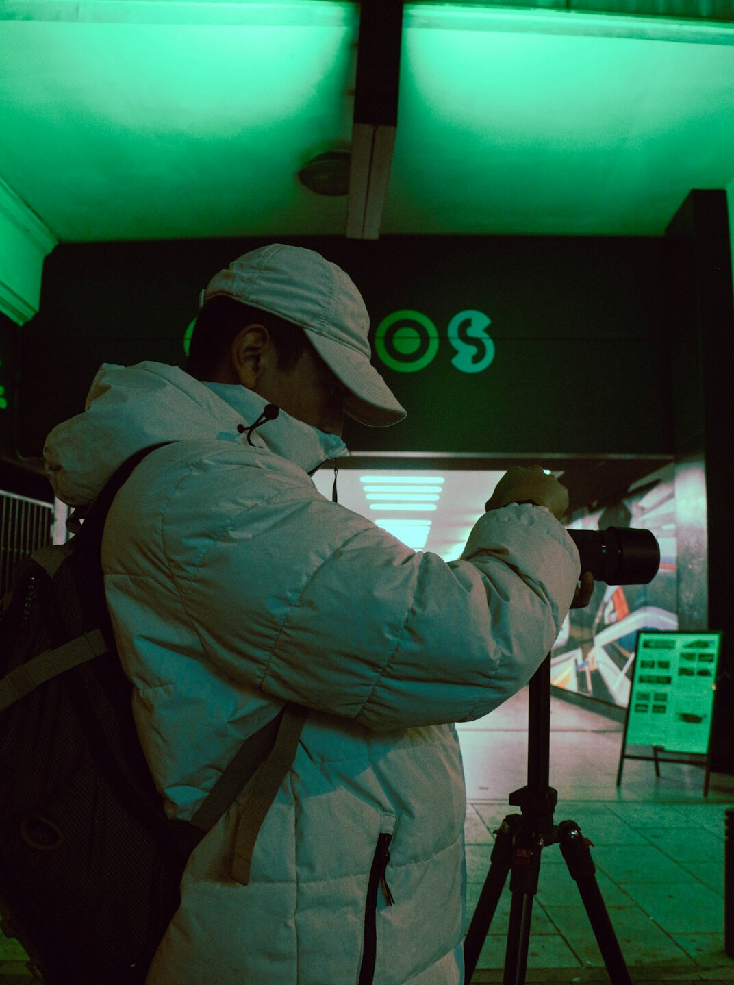 Professional cameraman operating a broadcast camera on a tripod indoors